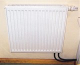 Panel radiators are a good alternative to baseboard where wall space is limited. Note the thermostatic valve on the upper right corner of the panel.