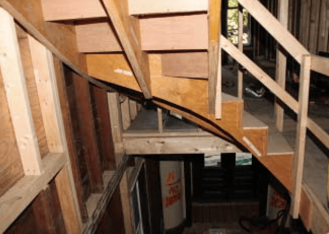 Temporary, 2x4 guardrails, screwed together for easy removal, provide fall protection for workers using the rough stair.