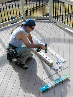 Figure 1. Hollow aluminum balusters fit over connectors screwed to the upper and lower rails. A home-grown jig speeds the accurate placement of the connectors.
