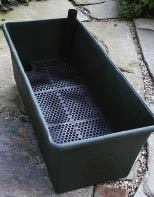 Figure 1. A self-watering container like the one shown above can be easily dropped into a wood frame.