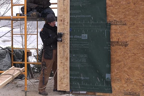 EcoCor carpenter George Reefer screws a wood I-joist to the outside of an existing stud wall for a field-constructed EcoCor deep energy retrofit in Newcastle, Maine.