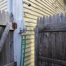 The shower fixture is very basic and inexpensive: Faucets and gooseneck shower head. Garden hose makes up the supply pipe.