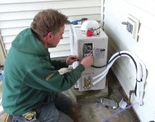 ReVision Energy’s Dave Ragsdale connects the control circuit of the outdoor unit of a 1-ton Fujitsu mini-split on a home near Portland, Maine. In combination with a wood stove, the mini-split will mostly idle the home’s existing oil boiler, except during the coldest part of the year.