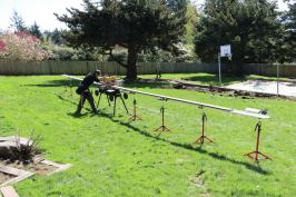 The saw stand has integral wheels that allow it to be easily moved over rough terrain, and it can be customized with additional fence sections and supports to fit long decking stock.