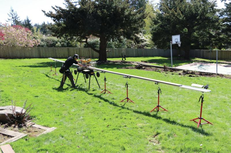 The saw stand has integral wheels that allow it to be easily moved over rough terrain, and it can be customized with additional fence sections and supports to fit long decking stock.