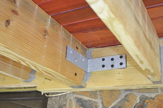 On a second-story deck, a building inspector may accept galvanized L-brackets fabricated from 1/4-inch steel and attached to the deck framing and house framing with structural screws as shown, in lieu of the threaded-rod hold-down anchors contained in the IRC.