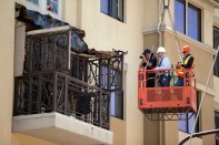A Berkeley police officer and two engineers in a hanging basket photograph a balcony collapse at an apartment building on Kittredge Street in Berkeley, Calif., Tuesday, June 16, 2015. Six people were killed and seven others were taken to area hospitals. (D. Ross Cameron/Bay Area News Group Archives)