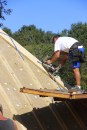 A framer nails reinforcing steel straps to 2x4 furring at the hip, applied over six inches of Roxul rockwool insulation.