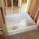 Fiberglass can be an effective shower pan material. Fiberglass cloth is fitted in the pan area, then is impregnated with resin to form a waterproof pan.