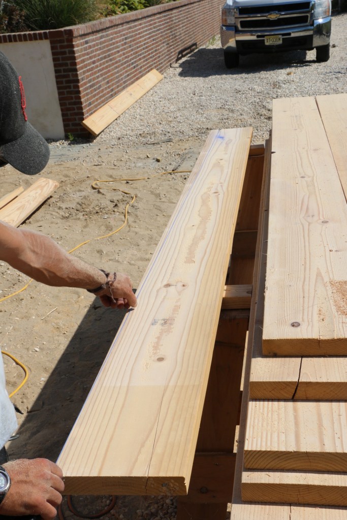 The deck starts with the joists tapered to provide drainage. A snapped chalk line sets the lope at 1/4 inch per foot.