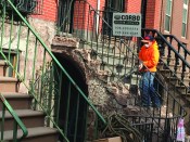 The typical stoop on a brownstone row house was built with an open stringer. Here, a worker begins a repair by chipping off all of its brownstone finish with a rotary hammer.