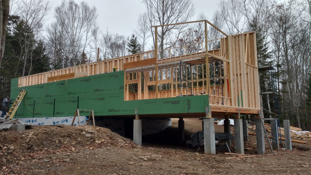 The largest element in the house (shown during framing) is a long, parallelogram-shaped main room with a two-story vaulted space.