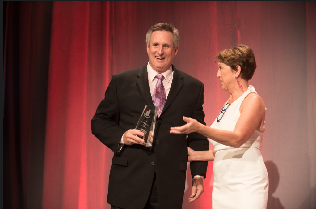 At the Awards Gala in New Orleans, Steve Barkhouse receives the 2018 Impact Award from Victoria Downing, president and chief inspiration officer of Remodelers Advantage.