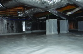 A view of an Addison  Homes “encapsulated”  crawlspace, showing the  company’s current standard  features: a 20-mil poly  ground cover; 1.5-inch foilfaced  insulation on the walls;  and an “inspection strip” at  the top of the block walls to  allow termite inspections.  The masonry-wall top is  coated with waterproofing  to prevent vapor intrusion.