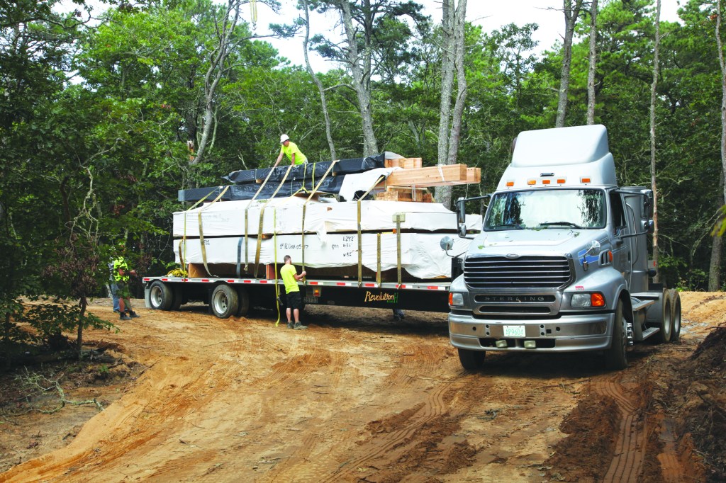 The parts for the house come on big flatbed trailers, shrink-wrapped, labeled, and numbered for assembly.