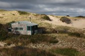 Sunrise bursts through overcast skies lighting up the Fowler Dune Shack, my refuge for a week.