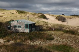 Sunrise bursts through overcast skies lighting up the Fowler Dune Shack, my refuge for a week.