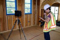 A Multivista technician uses a Matterport scanner and an iPad to create an accurate, photo-realistic virtual model of a Risinger Homes building under construction in 2018. At the same time, the tech is taking hi-resolution still photos of some locations, which can be keyed to the virtual model of the building.