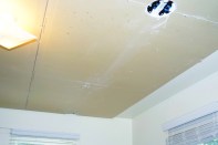 The radiant-panel ceiling, left exposed in the author’s offices for educational purposes, consists of a gypsum board layer over aluminum heat-transfer fins, backed by a 1 1/2 -inch layer of EPS insulation. Ink patterns on the surface of the drywall help installers avoid screwing into and puncturing coolantcirculating tubing within the panels.