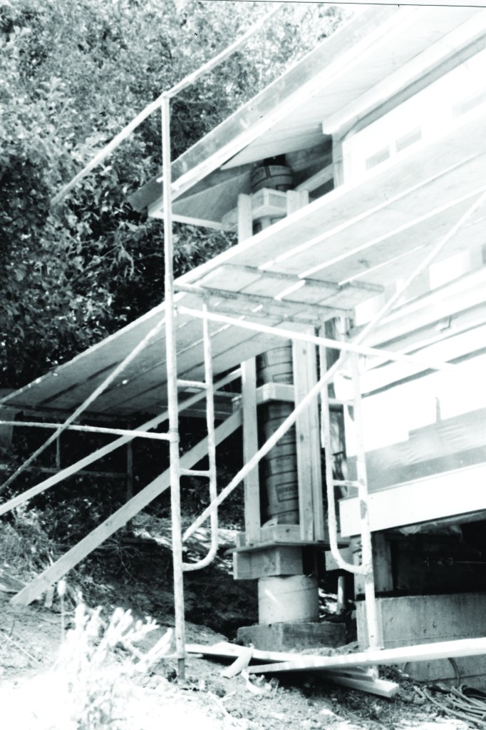 The stepped concrete column (whose formwork is visible behind the scaffolding) was costly to construct for several reasons, including complexity and difficult access. Most impactful, the column was to serve as a prominent finish item, so all forming and concrete installation had to be meticulously controlled.