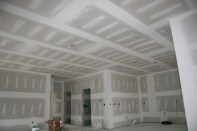 Here's the goal. The most common level of drywall finish is Level 4, shown here, in which seams and corners have been taped, then coated (along with fasteners) with two coats of joint compound, and sanded with a fine-grit paper to remove imperfections. If the room will be painted with anything other than a flat paint, the author recommends a Level 5 finish, which includes a skim coat of joint compound applied over the entire surface.