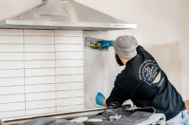 In this photo (above), the author tiles a backsplash. (The completed kitchen is shown further down in this article.) . His company, Jon Beer Contracting, self performs almost everything it can to control quality.
