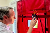 Image of man using tester device.