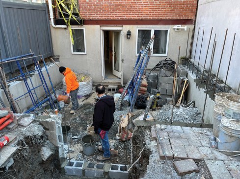With the back patio demolished, block work begins.