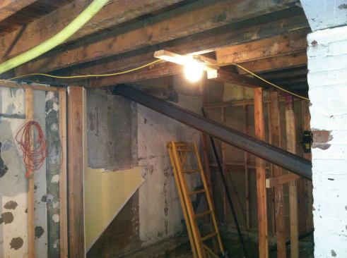 It took three of us to put them roughly in place, setting one end up in the 12-inch-wide pocket we had chiseled out of the party wall.