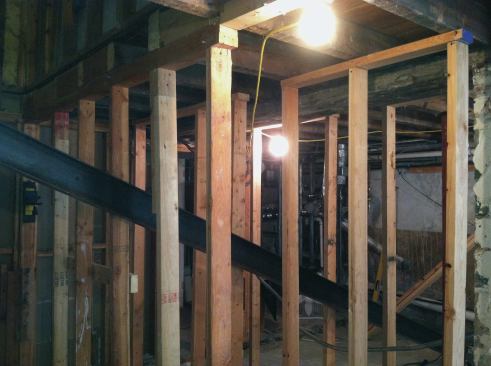 We shored up the existing floor system with temporary 2x4 stud walls, placing them around the steel ...