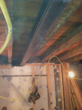 We lifted the W6x9s in place, pushing them into the 8-inch-deep pocket and at a slight angle along the horizontal plane at the wider, chipped-away side of the pocket. We then moved on to installing the Microlam beams.