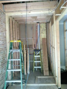 In order to redirect the floor and roof loads from above—leaving the new steel to support just the first floor—we used a 5 1/4-by-14-inch LVL beam in the second-floor framing and posted down to new footings in the basement. Once new subflooring covered the infilled opening, we started framing the powder room and closet.