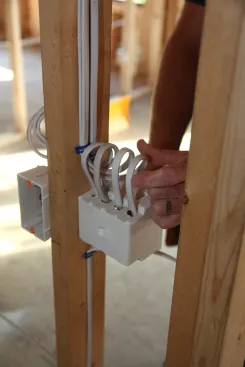 The author feeds the cables into the switch box leaving a loop in each one. Again the loop provides extra cable in the event that one of the conductors is damaged during the drywall installation.