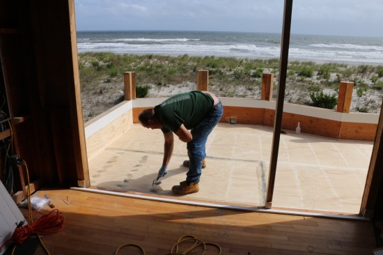 The installer covers the nail heads and plywood seams with a two-part filler.