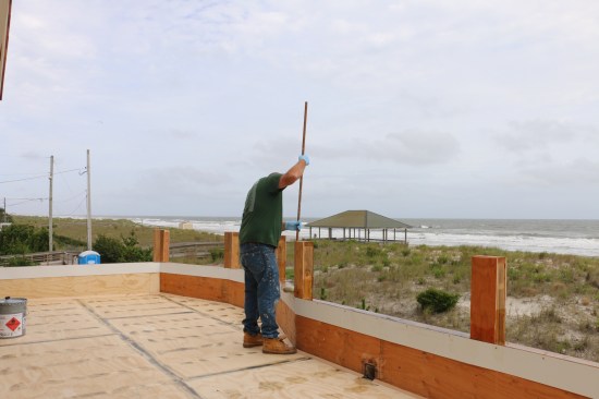 When the prep work is done the installer hot-coats all the surfaces starting with the tops of the parapet walls.