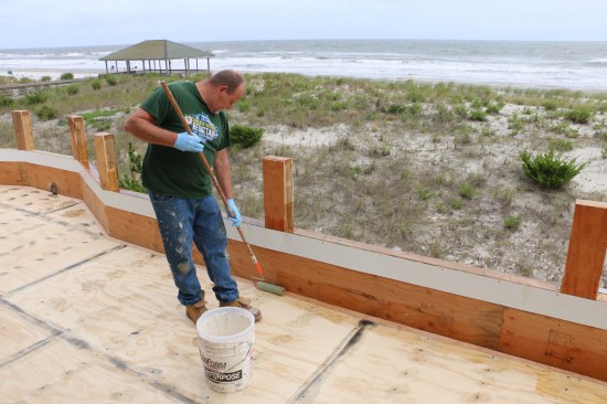 Next the installer applies a coat of resin on both sides of the fillet. When that is finished the field is hot-coated and left to cure.