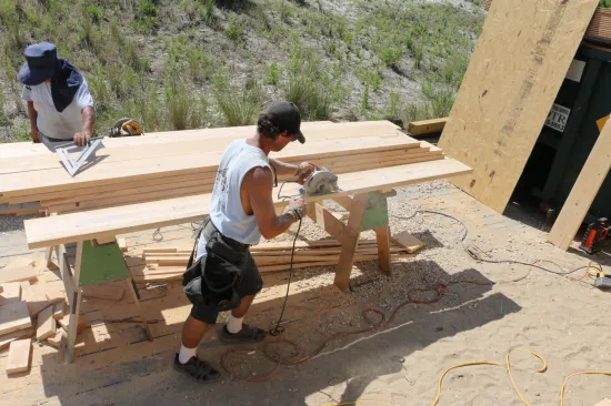 A circular saw rips the joist to the snapped line.