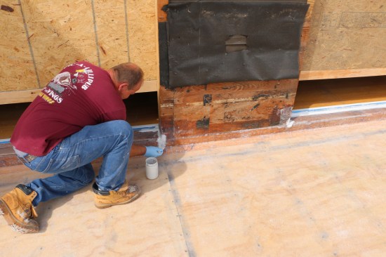A two-part gelcoat is the final finish on the fiberglass deck. Here the installer uses a disposable brush to coat problem areas.