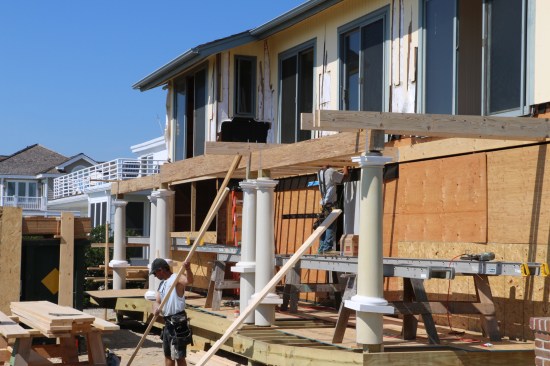 Because of the nature of this porch, parts of the floor was framed with dropped beams (with the joists resting on top of the beam) and the center section framed with a flush beam (joists mounted on the side of the beam).