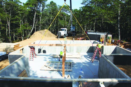 After glulam carrying beams supported by posts tenoned into them are dropped into place.