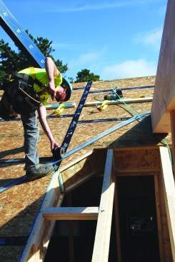 Then he Zip System tape seals the roof-panel seams.