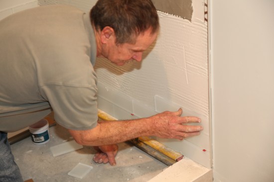 Press the tile into place, sliding it side to side slightly to embed it fully.