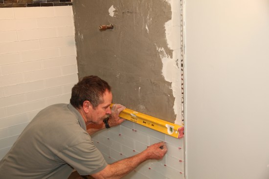 Insert tapered spacers to separate the tiles and leave the proper grout joint.
