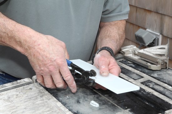 Using glass-tile nippers, carefully break out the glass over to the line.
