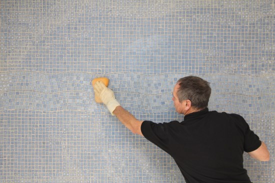 As with regular tile, remove excess grout with a clean sponge. After it dries, remove the grout haze with a terry cloth towel.