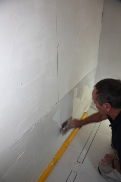 Coat the entire layout surface with glass-tile mortar before combing it with a 3/16-inch square-notched trowel