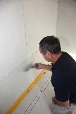 Knock down the ridges left from the trowel using a flat-bladed taping knife.