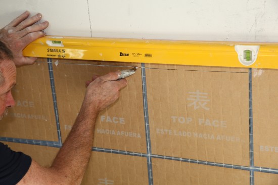 If any tiles need adjusting, slit the paper with a razor knife.