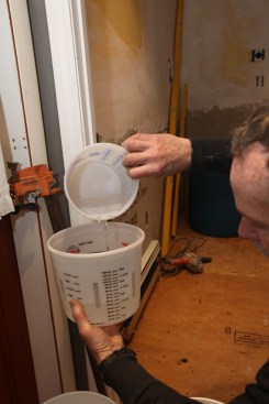 The author carefully measures the amount of water needed for each batch of leveler.
