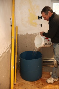 The author pours the precisely measured water amount into the mixing bucket.